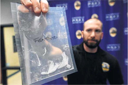 Greenfield Police officer Nathan Garner holds a bag with the confiscated drug Fentanyl. Officials are reporting an increase in overdose deaths in the State of Indiana and across the nation. In Hancock County law enforcement are faced with similar problems. Staff photo by Tom Russo
