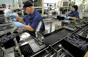 ON DOWN THE LINE: A Delphi Electronics &amp; Safety employee in Plant 7 brings up the rear of an assembly line, putting the final touches on a circuit board. (KT file photo)