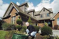 Mike Minars works in his Deerbrook Village yard Thursday afternoon. Minars, who owns a market in Albany, has lived in the community for the last seven years and supports a Yorktown annexation. By MELANIE MAXWELL