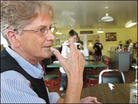Mary Bruner smokes a cigarette in the Wall Street Cafe during her lunch break. Bruner, who works in downtown Jeffersonville, thinks a smoking ban in resteraunts is unfair to the business owners. Jeffersonville's smoking ban is only one vote away, but the vote is expected to be a close one.
