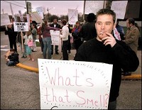 Shayne Anthony smokes while protesting the smoking ban with a group outside the City/County Building in Jeffersonville on Monday night.