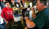 Bartender Elizabeth Bisel talks with regular Robert Winters as he has some beers and a smoke Friday at The Locker Room in The Village. KURT HOSTETLER / THE STAR PRESS