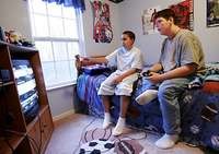 GAME TIME BLAMMED: Damien Mitchell, 13, (above right) plays a video game with his friend Matt Mugumya, 12. Experts say the hours many kids spend watching TV and playing video games is a factor in childhood obesity. More active today, Damien is down to 240 pounds from nearly 320. - Matt Detrich / The Star