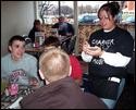Storie’s waitress Tiara Holbrook, far right, serves members of the North Decatur basketball team as smoking customers loom behind them.
