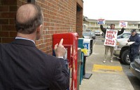 Before a town hall-style meeting Wednesday in Angola, Daniels asks a protester to check the facts on the Toll Road lease plan. Photo by Dean Musser Jr./The Journal Gazette