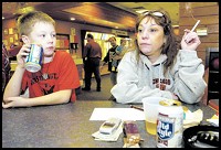 Debbie Pulido (above) of the east side of Chicago smokes a cigarette while watching her son Matthew, 8, bowl in his league at Olympia Lanes in Hammond. Matthew said that most of his family smoked and he was trying to get them to quit. "Keep trying," his mother said. (Brian Pierro / Post-Tribune)