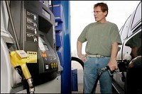 Bob Hollis, of Chicago, fills up his truck with gasoline Thursday at Fred's Mini Mart in Shadeland. Hollis owns a farm in West Point and travels to the area frequently. The gas station features the yellow-handled E85 ethanol pumps along with gasoline and diesel. The price of E85 on Thursday was the same as regular unleaded, $2.57. By Tom Leininger/Journal and Courier