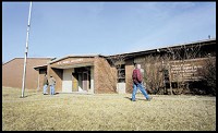 Members of English Lake Church scour the grounds of an old Army Reserve building in North Judson. The building, which has been shuttered for 10 years, is being sold at auction, with bids accepted online. (Lisa Schreiber / Post-Tribune)
