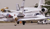 A passenger exiting a private jet walks through parked aircraft at the Palwaukee Municipal Airport in Wheeling, Ill. Although the airport has no commercial passenger service, it handled 122,000 landing and takeoffs in 2005. Fifty-seven corporate jets are based at the airport, which is jointly owned by the communities of Wheeling and Prospect Heights. JON L. HENDRICKS | THE TIMES