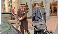 Conrad Hotel doorman Joe Gregory assists an arriving guest at the hotel.