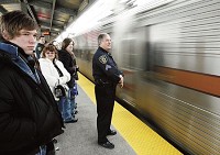 NICTD police Sgt. Mike Huston watches Wednesday as a Chicago-bound South Shore train arrives at the East Chicago station. Alcohol will be prohibited on the trains on News Year's Eve. JOHN J. WATKINS | THE TIMES
