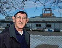 Former Arvin Meritor employee William Whited stands outside the plant where he worked. William's father helped build the structure on top of the building (shown in background) that moved transformers. (Photo by April Knox)