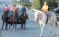 Jessica Spence (from left), Denise Spence, Harly Spence and Alyssa Garrison reach the intersection of College and Shadowlawn Avenues on horseback on their way to Tzouanakis Intermediate and Deer Meadow Primary schools Thursday.