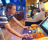 Brent Serre plays a video golf game with friends at Buffalo Wild Wings Grill and Bar. Barring a successful court challenge, Fort Wayne bars will become smoke-free Friday. Cathie Rowand/The Journal Gazette
