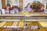 From left: Maureen Madden, Mary VanCamp, Tammy Spillers and Theresa Kacmarik bag cookies for customers at the Cookie Cottage. Photo by Samuel Hoffman/The Journal Gazette