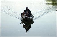 A fisherman uses his electric trolling motor to navigate a narrow channel at Shadyside lake Tuesday evening. Don Knight / The Herald Bulletin