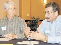 Jim Scheuk, left, listens while Pat Vercauteren discusses his ideas to reform local government Wednesday evening at the Franklin College Napolitan Student Center. Photo by Brent Bohlke