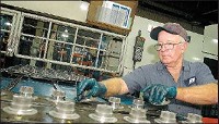 Wilson Puckett helps produce transmission parts at PMG Indiana Corp. in Columbus. The Republic photo by Mike Dickbernd