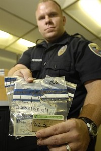 Elkhart Police Detective Jay Peterson holds several evidence bags containing false identification documents used by illegal immigrants to obtain jobs. Peterson was photographed at the E.P.D. Tuesday, November 13, 2007. Truth photo by Jennifer Shephard