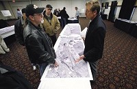 EJ&amp;E Railway employee Al Huber, left, of Calumet Township, talks to Bill Burgel, of the Environmental Impact Study Project Team during the Surface Transportation Board meeting Wednesday at the Genesis Center to provide information and get feedback about Canadian National Railway's plan to purchase the EJ&amp;E Railway, which would increase rail traffic on the EJ&amp;E three-fold through towns like Griffith, Schererville, Dyer, and the city of Gary. John Luke | The Times