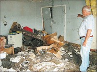 Inside Mariah Foods, nearly everything was soaked with water. Bill Jones, assistant general manager, looks over the devastation that included furniture, equipment and files swirled around and caked in mud. Brenda Showalter/The Republic photo
