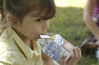 Mackenzie Tapia drinks a carton of milk as she eats lunch near the pool of Twin Pines Mobil Home Park in Goshen Wednesday, July 2, 2008. The lunch was offered as part of the Goshen Schools Summer Food program, which provides free lunches from the United States Department of Agriculture. Truth photo by Jennifer Shephard