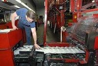 Pressroom foreman Dave Doughty reaches for an early copy of the Palladium-Item coming off the press. Today's issue is the final P-I to be printed in Richmond. (Palladium-Item photo by Steve Koger)
