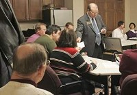 Chris Waymire, coordinator of the WorkKeys Service Center at Tecumseh Area Partnership Inc., passes out literature Monday at a weekly meeting of the Business and Professional Exchange. By Michael Heinz/Journal &amp; Courier