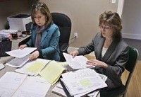 Susan Parkinson (left), a caseworker, and Fairfield Township Trustee Julie Collins review paperwork for their clients Thursday at 718 Wabash Ave. in Lafayette. By John Terhune/Journal &amp; Courier