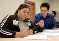 Keshia Silva, of Frankfort, gets help Tuesday on solving fractions from learning aid James Nakajima at WorkOne's Learning Lab. By Brent Drinkut/Journal &amp; Courier
