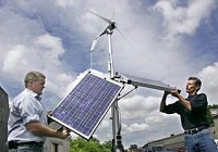 Issac Slaven (left) and J. Michael Revalee position a portable solar and wind power unit Thursday in the parking lot behind Griffin Hall at Ivy Tech Community College. Slaven is the sustainable energy director at Ivy Tech. Ivy Tech is the first college in the state to offer a sustainable energy program. Revalee is a student in the program. By John Terhune/Journal &amp; Courier