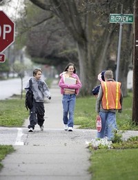 Courtney Winter, right, and her younger brother Jamison Winter approach the Riverview Elementary crossing guards as they walk to school Wednesday, April 29, 2009. The Elkhart Community School`s effort to cut transportation cost may result in revised walk zones for students. Truth Photo By Jennifer Shephard