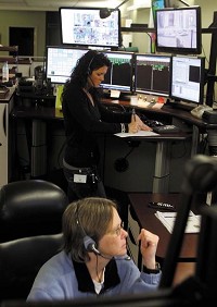 On the job: Lynn Vonreuss, bottom, and Kasey Lewis work the county side of the combined dispatch center at the Howard County jail. KT photo by Erik Markov