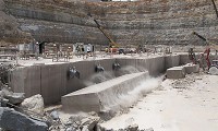 A block of limestone lands on the ground after being cut from the shelf at Indiana Limestone Co. Central Quarry on Victor Pike. The three black airbags inflate to separate the cut block, which is 54 feet long, 12.5 feet tall and 5 feet thick, weighing about 500,000 pounds. David Snodgress | Herald-Times