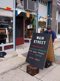 Sidewalk advertising: Main Street Restaurant co-owner Dan Kennedy sets up a sign in front of the restaurant for the dinner crowd Thursday afternoon in Rosedale. Tribune-Star/Joseph C. Garza