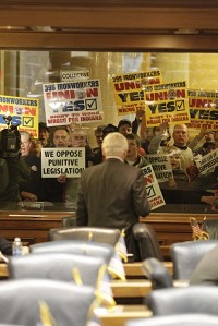 
Behind an empty Democratic side of the chamber Rep. Jeff Espich, R-Uniondale, watches protesters protests during the opening day of the 2012 session at the Statehouse in Indianapolis, Wednesday. AJ Mast | The Times of Northwest Indiana
