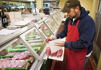 Mike Breaux packages ribeye steaks Thursday at the D&amp;R Market on the eastside of Lafayette. He says he's yet to see a significant shift in prices. / By Brent Drinkut/Journal &amp; Courier