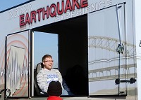 What a "7" feels like: Indiana State freshman Andrew Rettig of Indianapolis tries to stay in his seat as he is jostled in the Quake Cottage, an earthquake simulator, Wednesday on the Indiana State campus. In the foreground is Walter Gray of the Indiana Geological Survey. Staff photo by Joseph C. Garza