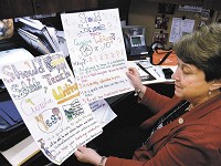 Indiana State Sen. Jean Leising shows some posters made by schoolchildren who support her legislation to require the teaching of cursive writing in Indiana schools. Staff photo Maureen Hayden
