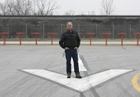 Gary Jet Center owner Wil Davis is urging Gary/Chicago International Airport officials to proceed with eliminating the railroad embankment seen behind him in this 2008 Times photo at the end of the main runway. But he wants them to hold off on undertaking the largest borrowing in airport history to complete the runway's expansion. Staff file photo