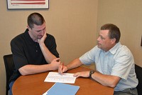 Purdue University College of Technology student Chad Clark goes over his class scheduling options with Student Services Coordinator Dave Riegle at the Anderson campus on Monday morning. Staff photo by Dani Palmer