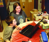 Cathy Bergin of Merrillville looks over son Zach's upcoming school schedule with him in advance of the first day of school Monday at the Indiana Connections Academy, a virtual charter school. | Post-Tribune photo