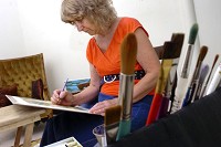 Artist Anne Maddox works on a watercolor Tuesday in her temporary studio at the Centrum Mall. Staff photo by Jeff Morehead