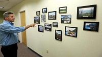 John Jensen talks about some of the photos that hang on the wall in the travel abroad office at Ball State University. These are just a few of the pictures that have been sent by students who have gone through the program. / Kurt Hostetler / The Star Press