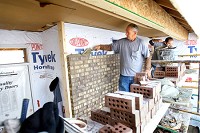 GOING UP: Dennis and Evan Macy with Macy and Sons Masonry lay bricks on the front of a house being built by VanNatter Construction in the Fredrick Farms subdivision. Staff photo by Tim Bath