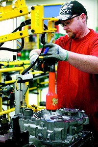 Internships, faculty visits to plants, visits by Chrysler employees to West Lafayette, and serious high-end research are all expected to be facets of a partnership between Chrysler and Purdue. Here, Chrysler ITP1 employee William Bennett removes data bolts and releases palette clamps on the line. Staff photo by Kelly Lafferty