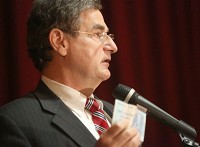 Indiana State Treasurer Richard E. Mourdock uses a $1 trillion note from Zimbabwe to make a point as he addresses the Gary Chamber of Commerce on Monday at Majestic Star Casino. Staff photo by John J. Watkins