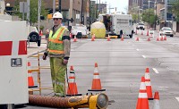 An Indiana &amp; Michigan Power Co. worker stands over a manhole on Lafayette Boulevard Saturday afternoon in downtown South Bend as crews work to restore power&nbsp;to the area. SBT Photo/GREG SWIERCZ