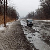 Cars dodge potholes on a long stretch of Martin Luther King Drive, north of 35th Avenue in Gary Thursday. | Carole Carlson/Sun-Times Media