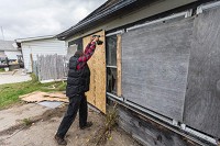Christopher Jones, Chief of Board-Up attaches a piece of chipboard to the garage of a house on the 1800 block of 19th street where a body was found on Sunday in Gary on October 21, 2014. | Jim Karczewski/For Sun-Times Media